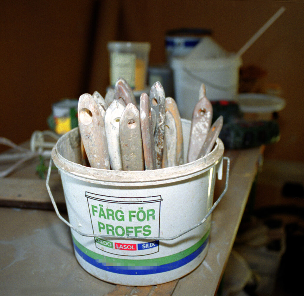 Penslar som står i en plastburk.