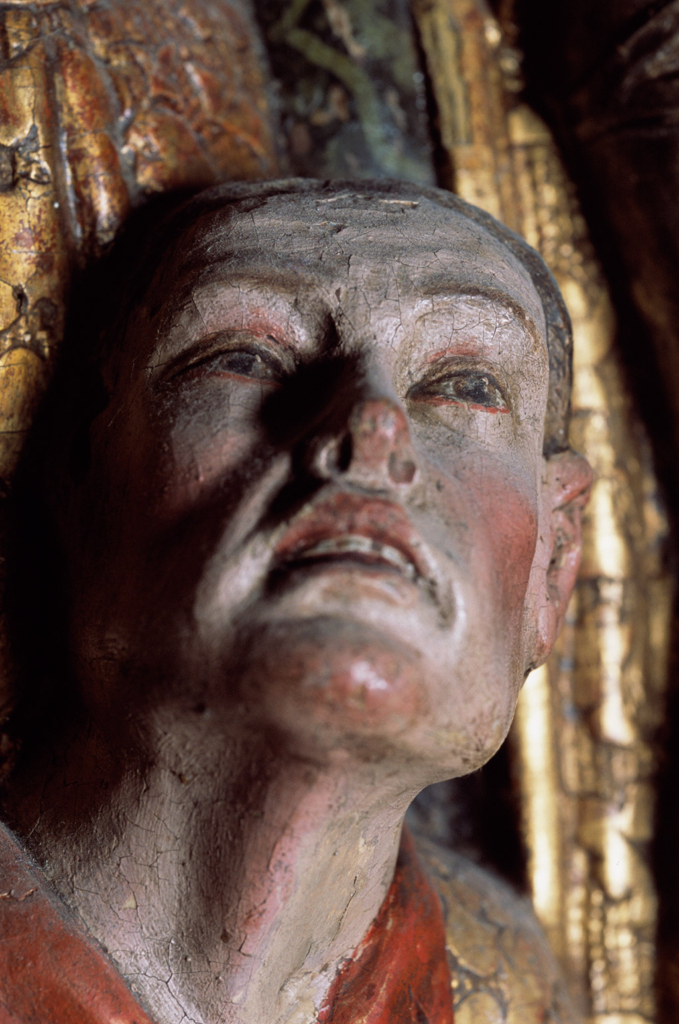 Snidad träfigur av ett kvinnoansikte.